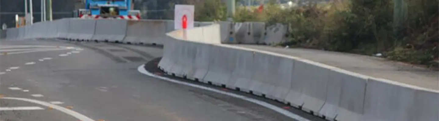 Highway with concrete safety barriers installed along the edge, enhancing roadside protection and traffic safety.