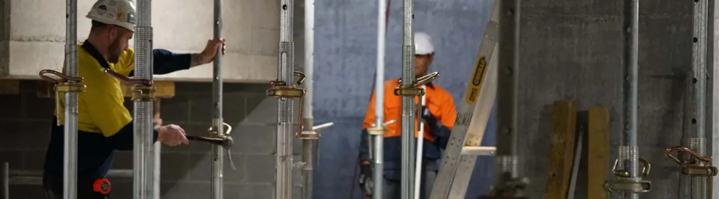 Workers installing temporary support props at a construction site to ensure structural safety and stability.