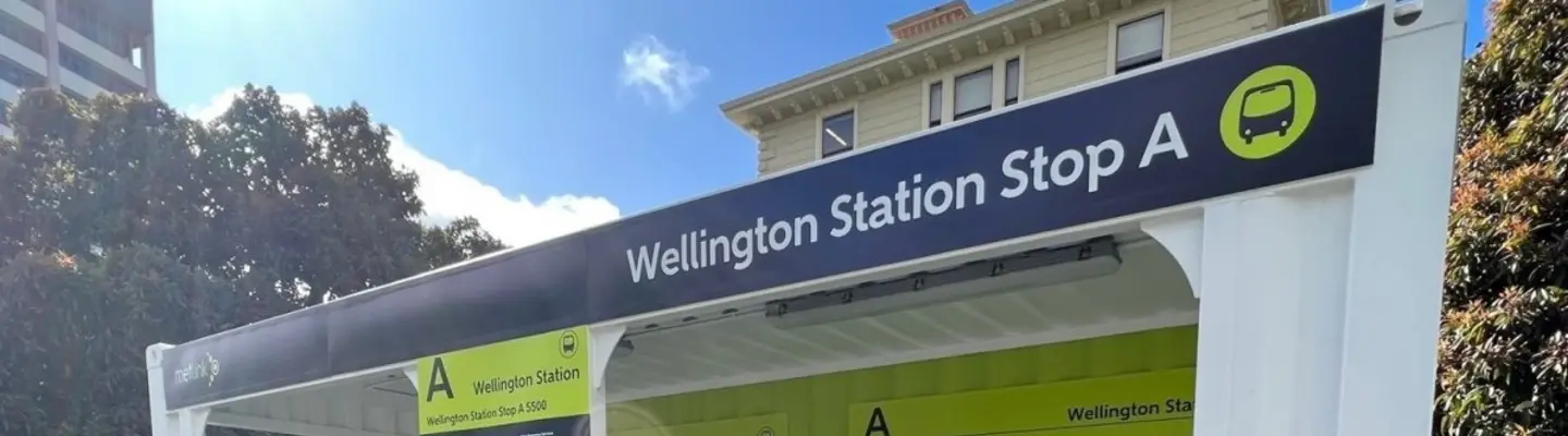  Temporary bus shelter constructed from repurposed container hoardings, providing shelter and seating for waiting passengers.