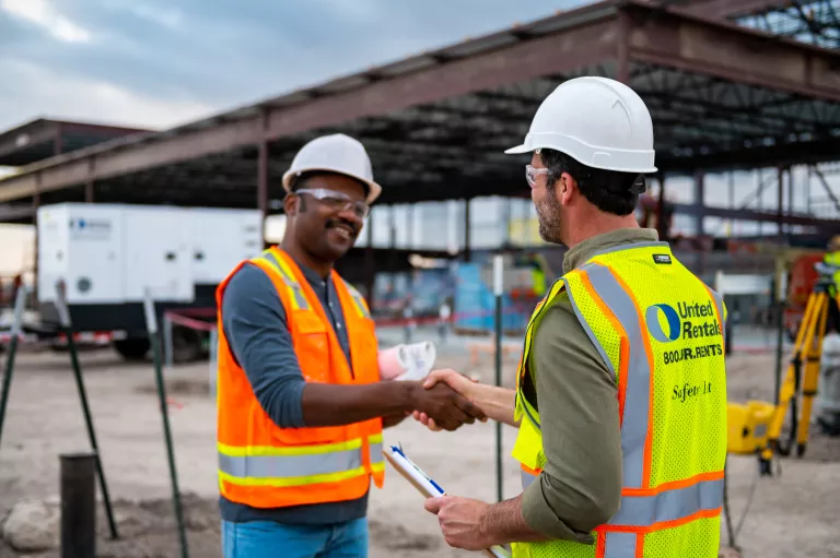 Workers in hard hats shaking hands
