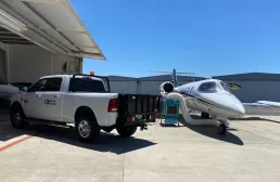 Camion stationné à l’extérieur d’un hangar à côté d’un refroidisseur localisé en service près d’un avion d’affaires