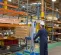 Elevador de materiales manual Genie de 700 – 1,000 lb y 6 – 12 ft azul y plateado sosteniendo un palé en un almacén