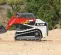 Red and white Takeuchi small track loader moving dirt