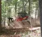 Red and white Takeuchi small track loader moving dirt on an incline