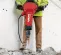 Red and black Hilti electric demolition breaker hammer being used to break up concrete