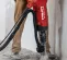 Aspiradora de polvo de concreto húmedo/seco eléctrica Hilti roja y negra usada mientras se rompe concreto