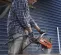 Orange and gray Husqvarna air concrete saw being used by a worker to cut concrete slab