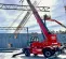 Red and black Magni 13,200 lb. variable reach forklift fully extended at a construction site