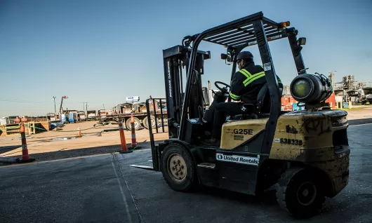 Worker using a forklift at job site
