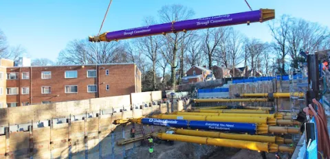 trench safety struts being placed into excavated hole