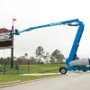 Blue Genie de 135 ft Brazo de elevación telescópico con tracción en las 4 ruedas extendido fuera de un estadio deportivo