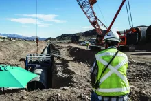 Construction manager looks at trench site