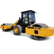 New flatbed equipment parked at a construction site, ready for loading materials with safety barriers nearby.