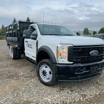 Angled front-left view of a white pickup truck with a black flatbed.
