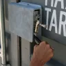 mano presionando hacia abajo la manija del contenedor para almacenamiento