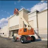 Orange JLG telescopic boom lift at a job site