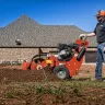 Orange Ditch Witch 11-15 HP walk-behind trencher being used on a lawn