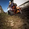 Orange Ditch Witch 48 in. walk-behind trencher in use next to a building