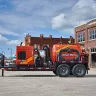 Orange Ditch Witch 512-575 CFM diesel powered vacuum trailer in a shopping center parking lot