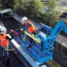 Blue Genie fall arrest platform boom lift in use at a work site