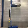 Blue 12 ft. Genie electric powered vertical mast lift extended in warehouse