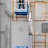 Blue Genie 15 ft. electric powered extended vertical mast lift with a worker on the platform