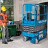 Blue Genie 19 ft. electric powered scissor lift going through a door in a building