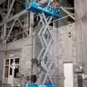 Blue Genie 20 ft. electric scissor lift fully extended inside a building
