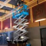 Blue Genie 30-33 ft. electric scissor lift extended inside a building