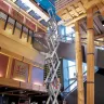 Blue Genie 30-33 ft. electric scissor lift fully extended inside a building