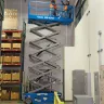 Blue Genie 39-40 ft. wide electric scissor lift extended inside a warehouse