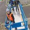 Blue Genie 39-40 ft. electric scissor lift extended at construction site