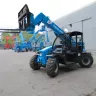 Blue Genie 5,000 lb. telehandler reach forklift parked outside of a building with other forklifts in the background