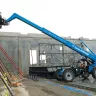 Blue Genie 6,000 lb. telehandler reach forklift with boom extended at a construction site