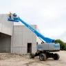 Blue Genie 4WD telescopic boom lift with boom upright and workers on the platform at construction site
