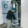 Silver Genie 24-25 ft. manual material lift being moved through an interior door