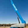 Blue Genie 180-185 ft. fully extended telescopic boom lift in front of a building