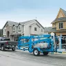 Blue Genie 46-50 ft. 4WD towable boom lift being towed by a pickup truck