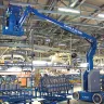 Nacelle élévatrice articulaire électrique Genie bleue de 9,1 m déployée en cours d’utilisation dans un entrepôt