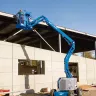 Blue Genie 34 ft. extended articulating boom lift in use at a construction site