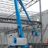 Blue Genie 80 ft. 4WD extended articulating boom lift at a construction site