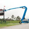 Blue Genie 135 ft. 4WD extended telescopic boom lift outside a sports arena