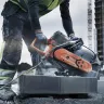 Orange and gray Husqvarna 16 inch Cut-off Saw being used to cut concrete