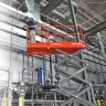 Orange and Gray Skyjack Electric Powered Scissor Lift on a job site