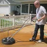 Black Mi-T-M 4,000 psi hydro scrubber surface cleaner being used to clean a wood deck