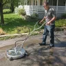 Black Mi-T-M 3,000 pressure washer rotary wash brush being used to clean an asphalt driveway