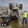 Black Mi-T-M 3,500 psi hot water pressure washer being used to wash a dump truck