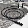 Black and silver Multiquip 2 horsepower electric concrete vibrator with hose attached at a construction site