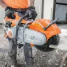 Orange and white Stihl 12 inch concrete cut-off saw cutting through concrete