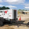 White Wacker-Neuson 20kW towable generator parked at a freeway construction site